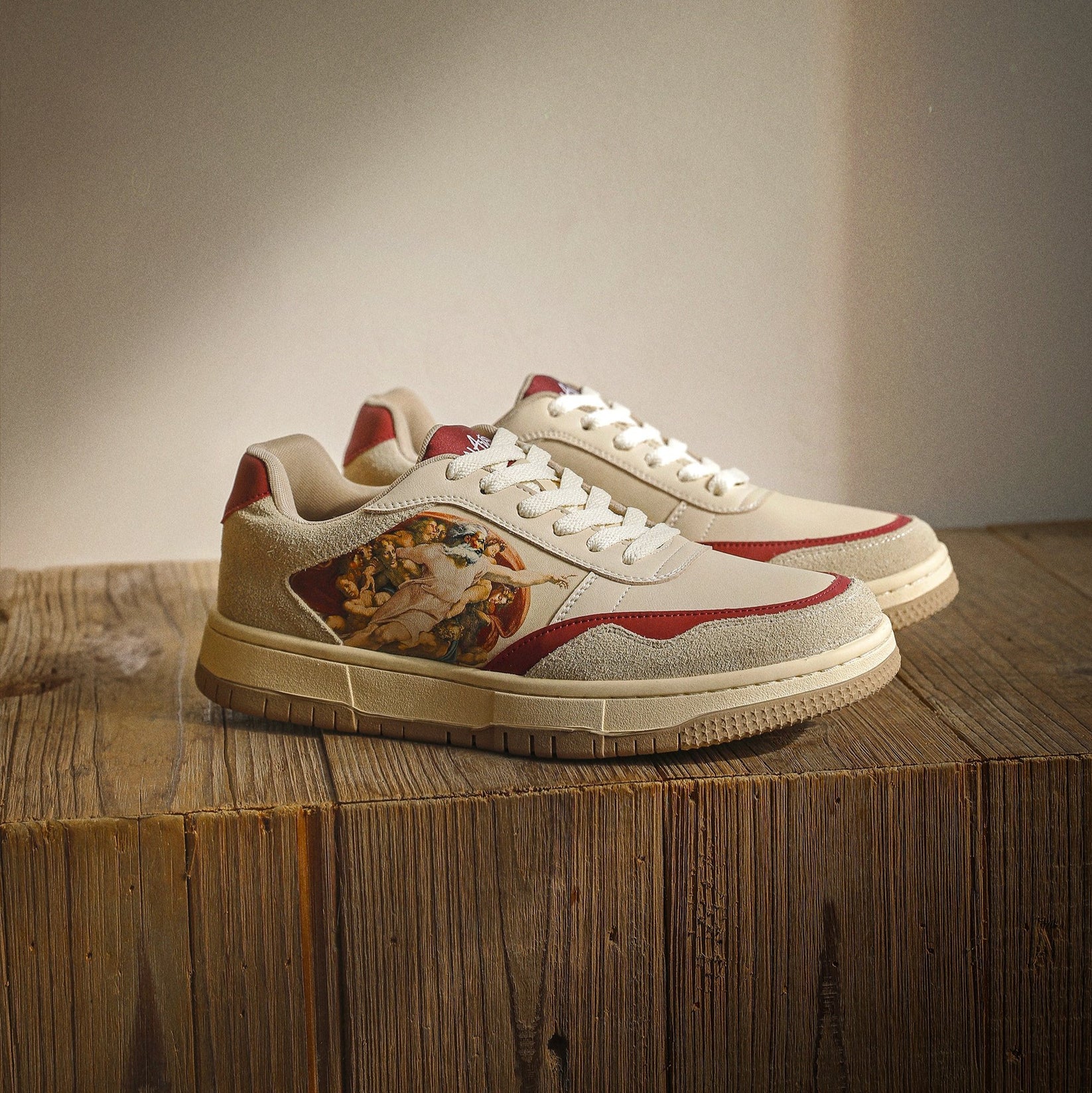 Stylish sneakers with artistic design on wooden surface.